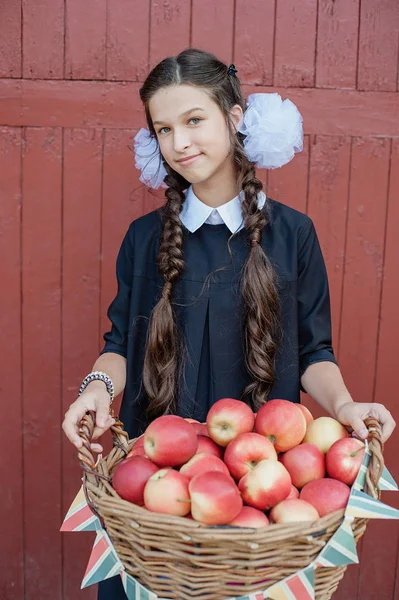 Portrait of a schoolgirl standing with apple on head — Stock Photo, Image