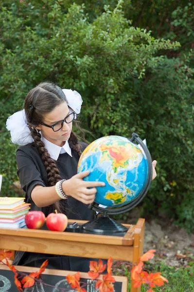 Porträtt av en vacker ung Skolflicka sitter vid ett skrivbord — Stockfoto