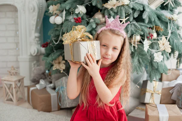 Симпатичная блондинка 5 лет с коробкой подарков у елки . — стоковое фото