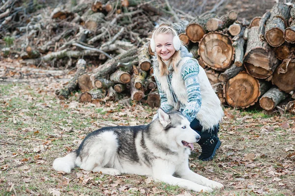 Jeune femme étreignant son chien husky — Photo