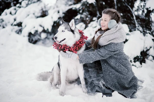 Bela menina na floresta de inverno com Husky siberiano. Símbolo de Ano Novo 2018 — Fotografia de Stock