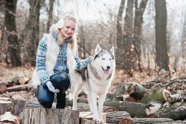 Jeune femme étreignant son chien husky — Photo