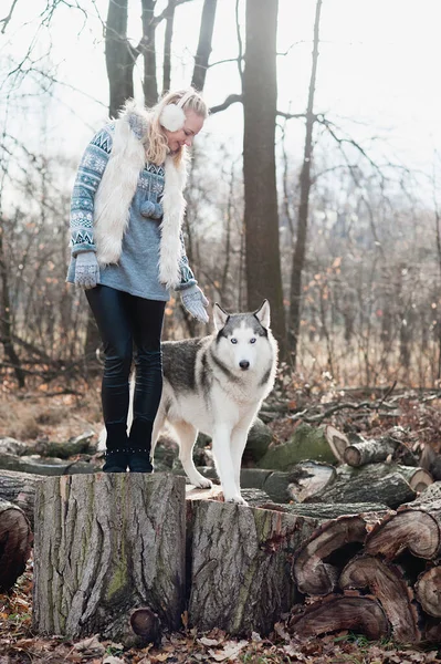 Jovem mulher abraçando seu cão husky — Fotografia de Stock