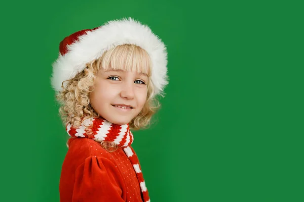 Boldog karácsonyt kislány Santa kalap élénk zöld élénk szín háttér. — Stock Fotó
