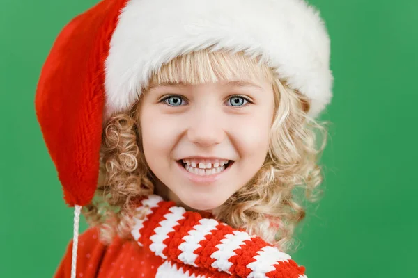 Feliz Navidad Niña en el sombrero de Santa sobre fondo de color vivo verde brillante . — Foto de Stock