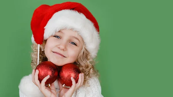 Boldog karácsonyt kislány Santa kalap élénk zöld élénk szín háttér. — Stock Fotó