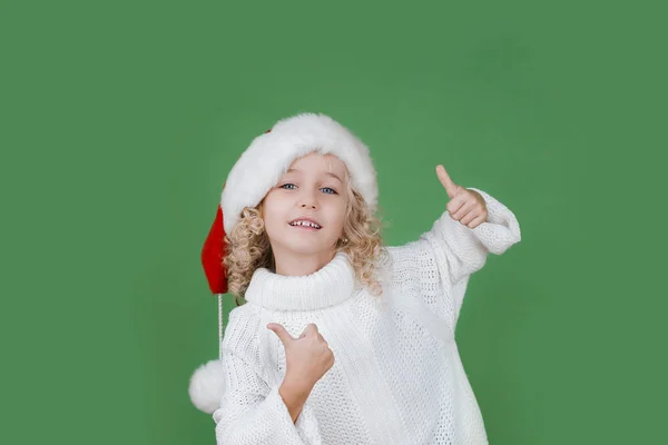 Feliz Navidad Niña en el sombrero de Santa sobre fondo de color vivo verde brillante . — Foto de Stock