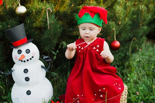 子供はジュリの木でクリスマスを待っています。クリスマスツリーの近くの小さな子供の肖像画。女の子がクリスマスツリーをボールで飾る. — ストック写真