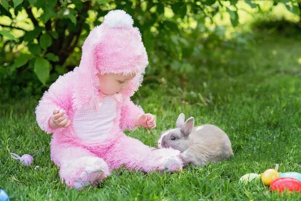 Barn leker med riktiga kaniner. Skrattande barn på påsk ägg jakt med sällskapsdjur kanin. — Stockfoto