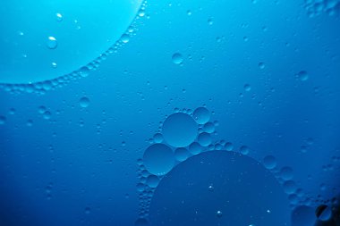 oil with bubbles on on dark blue background. Abstract background. clipart