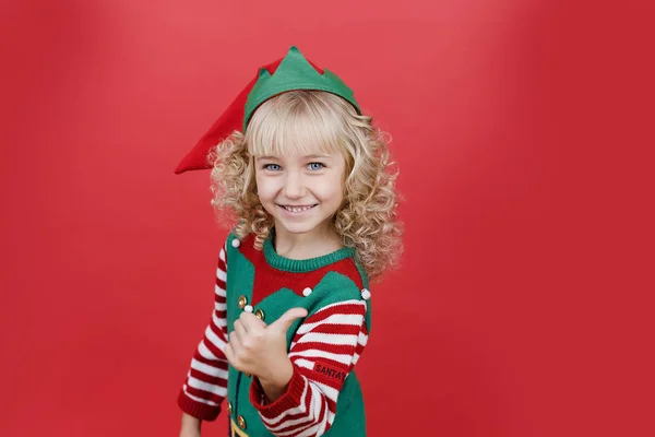 Kislány Santa elf segítő jelmez élénk piros élénk színes háttér. — Stock Fotó