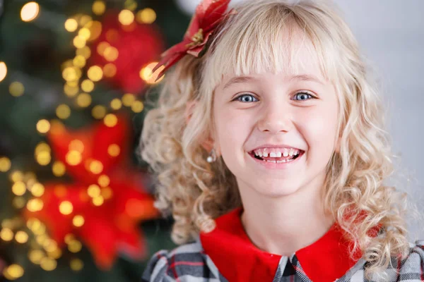 Közeli portré a kis aranyos mosolygós lány közelében díszített karácsonyfa. — Stock Fotó