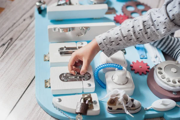 Bebê bonito da criança brincando com a placa ocupada em casa — Fotografia de Stock