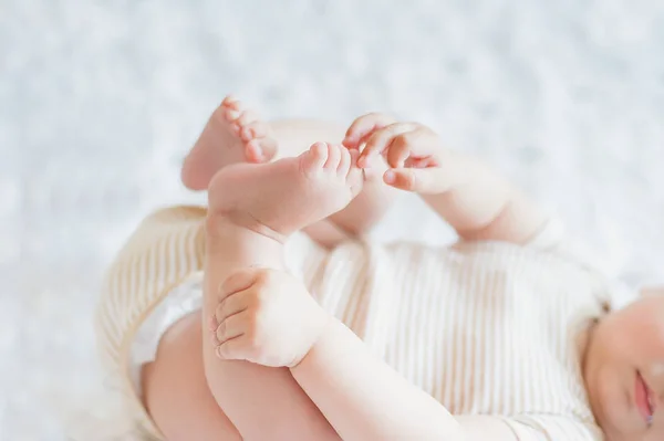 Close up of holding legs. Newborn 4 month skills concept. — 스톡 사진