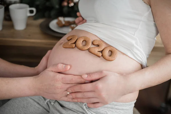 Καλλιεργημένη φωτογραφία της εγκύου που κατέχει τον αριθμό 2020 των μπισκότων τζίντζερ στην κοιλιά. — Φωτογραφία Αρχείου