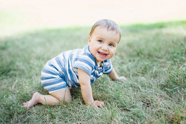 7 maanden kind kruipt op gras in de tuin, — Stockfoto
