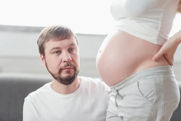 Feliz futuro pai ouvindo barriga de sua esposa grávida. gravidez pessoas e expectativa conceito fértil . — Fotografia de Stock