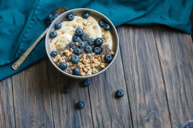 Sağlıklı kahvaltı berry smoothie kase muz ve yaban mersini ve chia tohumu ile granola ile tepesinde . vegan çiğ gıda konsepti 