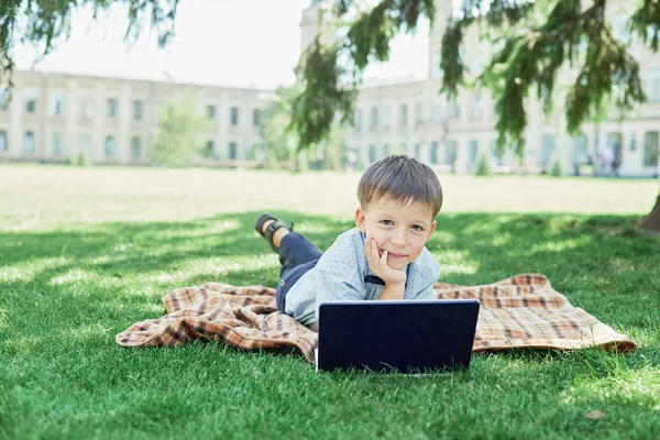 Groep basisschool kinderen Samenwerken aan de natuur in het park huiswerk maken op laptop — Stockfoto