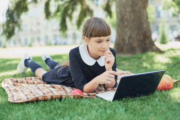 Groep basisschool kinderen Samenwerken aan de natuur in het park huiswerk maken op laptop — Stockfoto