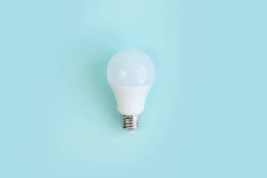 Mavi arka planda bir tane Led ampul. Enerji tasarrufu kavramı. minimalizm.