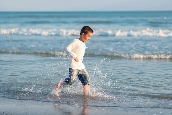 Pequena Criança Correndo Praia Água Espirrando Mar Azul — Fotografia de Stock
