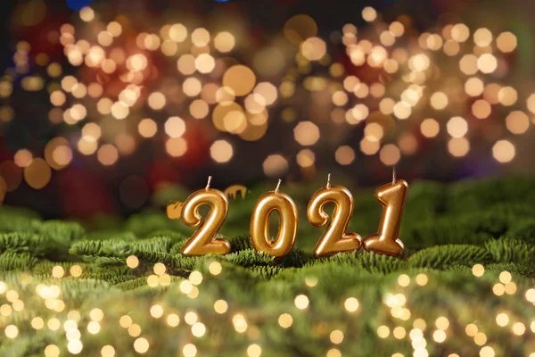 Latar belakang liburan Selamat Tahun Baru 2021. Angka tahun 2021 dibuat dengan membakar lilin emas dengan latar belakang meriah berkilau merah . — Stok Foto