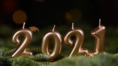 Tatil geçmişi. Mutlu yıllar 2021. 2021 yılının sayıları Bokeh şenlik ışıl ışıl arka planında altın mumlarla yapıldı. Yeni yılı kutluyoruz, yakın plan. Metin için boşluk