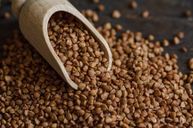 Kırsal arka planda kepçe ve karabuğday manzarası. Ham karabuğday arkaplanını kapat.