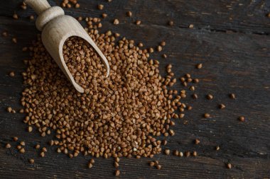 Kırsal arka planda kepçe ve karabuğday manzarası. Ham karabuğday arkaplanını kapat.