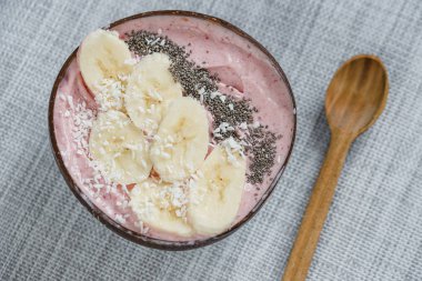 Üzerinde muz, granola ve fotokopi alanı olan chia tohumları olan sağlıklı kahvaltı meyve suyu kasesi.