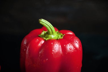 Siyah arka planda kırmızı tatlı biber. Taze kırmızı dolma biber ve su damlacıkları.