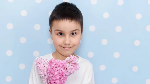 ピンクのヒヤシンスの花の花束を持ってかわいい男の子ギフトのための 母の日と女性の日の概念 — ストック写真