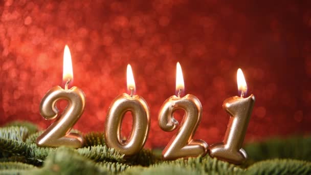 Nyaralás háttér Boldog Új Évet 2021. Az év számjegyei 2021 készült égő arany gyertyák piros ünnepi csillogó háttér. — Stock videók
