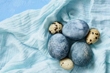 Mavi arka planda mavi Paskalya yumurtaları. Doğal olarak mermer taşlı amber çiçeğiyle boyanmış yumurtalar. Eko boya. Mutlu Paskalyalar.
