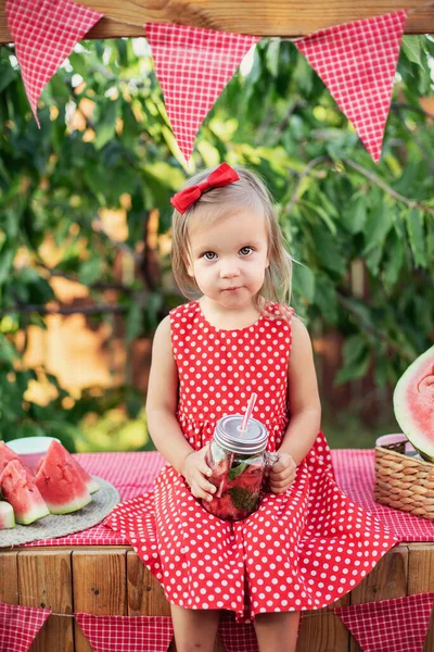 Limonata standı. Limonata satmaya çalışan sevimli küçük kız. Buzlu karpuz limonata ve nane şekeri kavanozlardaki yaz ferahlatıcı içecek gibi. Meyveli soğuk meşrubat. Kavanozda limonata içen çocuk