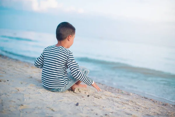 Uma criança a correr na praia. Férias. garoto feliz brincando na praia na hora do pôr do sol — Fotografia de Stock