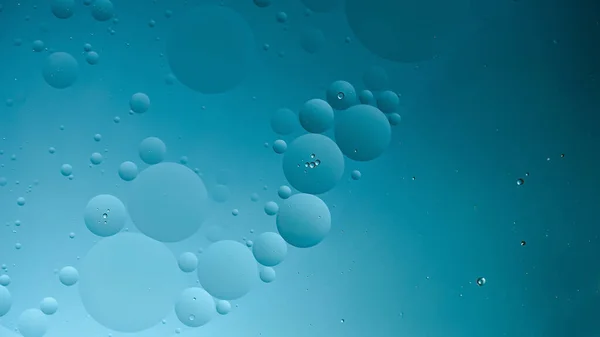 oil with bubbles on dark blue background. Abstract space background. Soft selective focus. macro of oil drops on water surface. copy space. air bubbles in water, horizontal format, social media 16x9