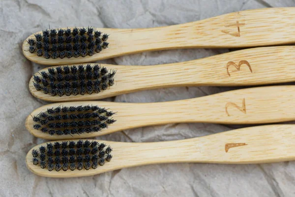 Set of bamboo toothbrushes with black brush bristles on paper background. Dental care with eco friendly tools