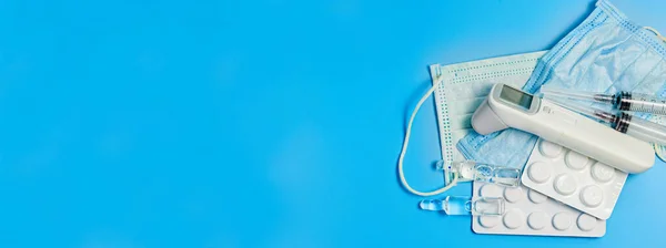 青の背景に薬の錠剤と温度計 ヘルスケアの概念 — ストック写真