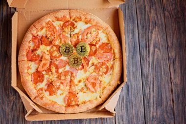 Bitcoin Pizza Günü, 22 Mayıs Bitcoin, ahşap masa üzerinde bitcoin ile taze pizza.
