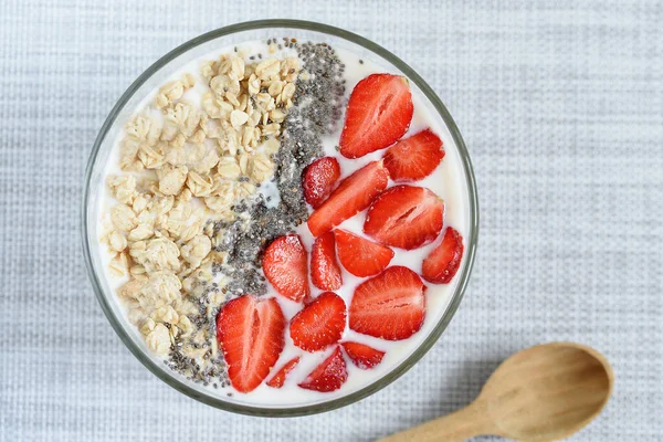 Healthy breakfast superfood smoothie bowl topped with granola and strawberry. close up. delicious berry smoothie bowl. vegan raw food. Selective focus. Flatlay