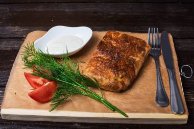 Karanlık bir arka planda, tahtanın üzerinde hazır yemek.