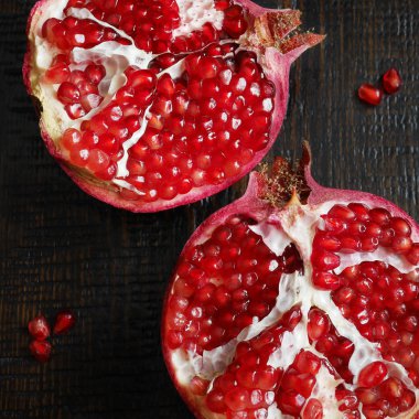 koyu ahşap zemin üzerine nar kesim içinde üstten görünüm 