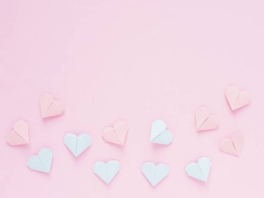 Pembe bir arka plan üzerinde kağıt origami kalplerin desen