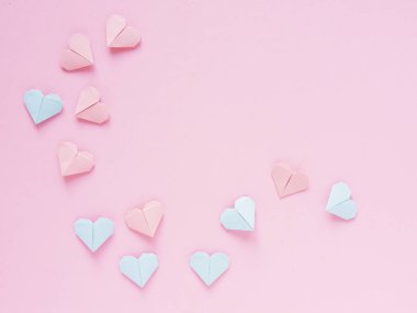 Pembe bir arka plan üzerinde kağıt origami kalplerin desen