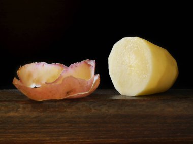 Koyu ahşap ve siyah arka plan soyulmuş patates yakın çekim