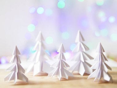 Kağıt origami ağaçlar ve bokeh parlamayı çelenk ile Noel ve yeni yıl arka plan.