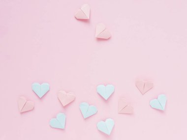 Pembe bir arka plan üzerinde kağıt origami kalplerin desen
