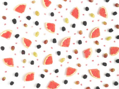 Greyfurt, böğürtlen, beyaz zemin üzerine nar, siyah ve Yeşil üzüm taneleri dilimleri